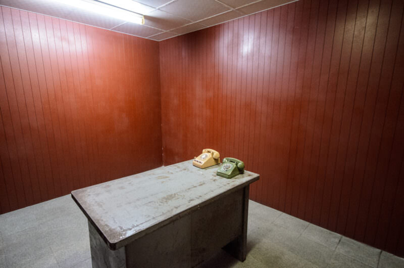 Two rotary telephones on a steel desk in a wood-paneled room of Reunification Palace's bunker