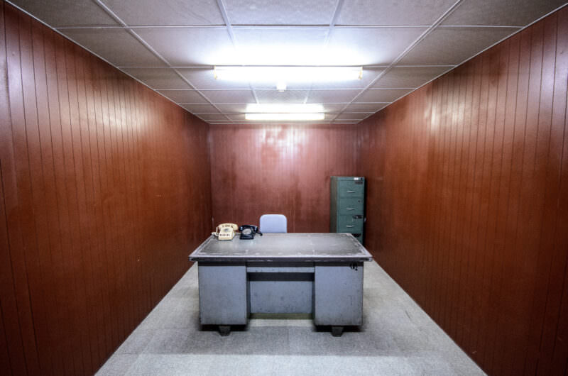 Metal desk with two rotary phones in a wood-paneled office inside Reunification Palace's bunker