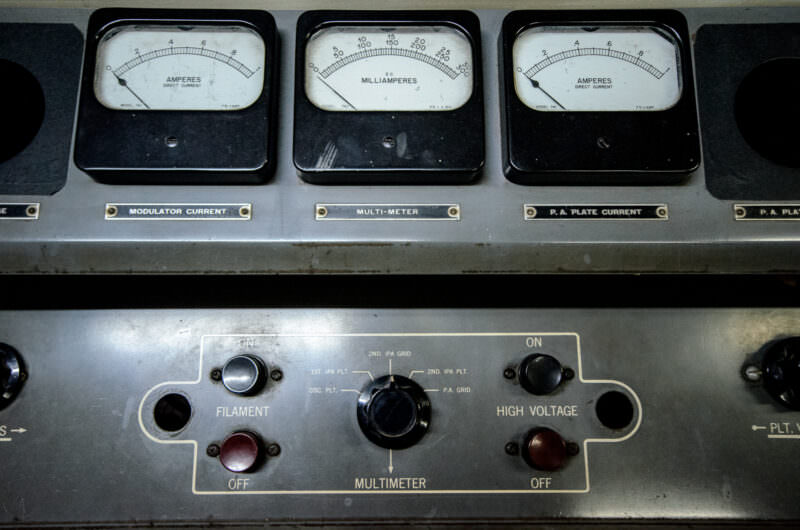 Close-up of analog meters and switches on a radio transmitter panel in Reunification Palace's bunker