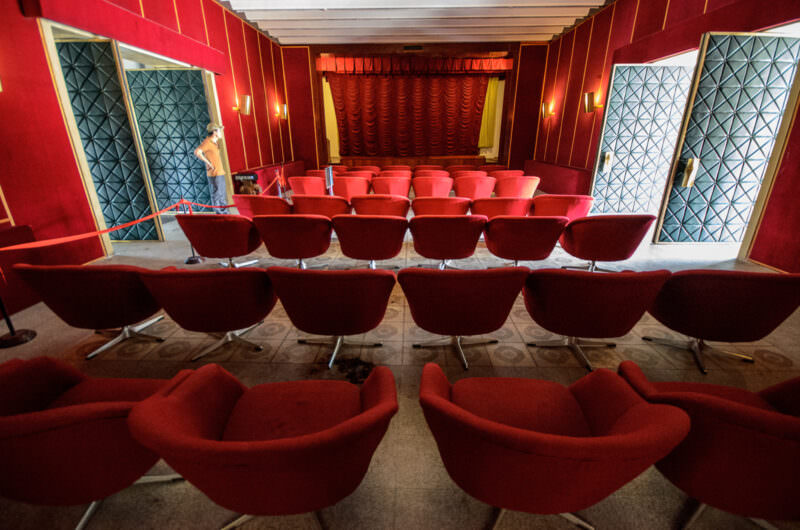 Rows of red swivel chairs facing the stage in Reunification Palace's private movie theater
