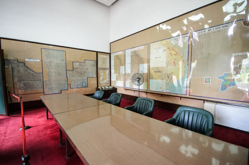 Conference table and green chairs facing military tactical zone maps in Reunification Palace's Map Room