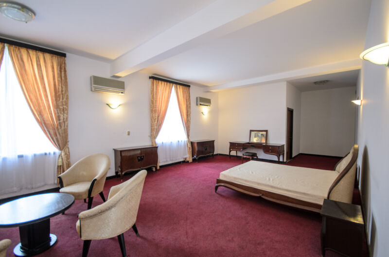 Wooden bed frame and tub chairs in the President's bedroom within Reunification Palace's private quarters