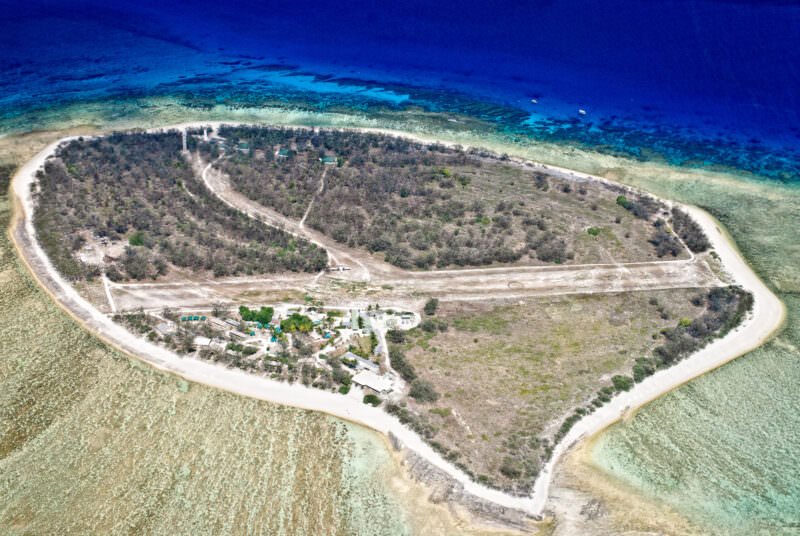 Aerial view of Lady Elliot Island showing grass airstrip, eco-resort buildings and heritage lighthouse