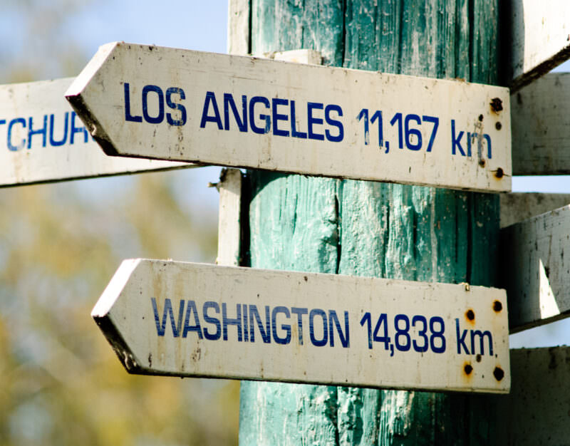 Weathered directional signs showing distances to Los Angeles and Washington from Lady Elliot Island