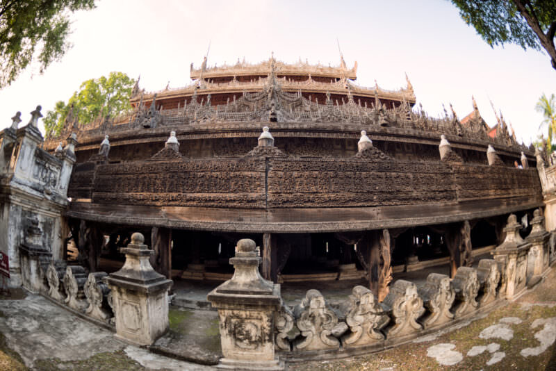 Shwenandaw Monastery silvered-teak exterior with unbroken carved registers, sandstone balustrade, and tiered pyatthat roof
