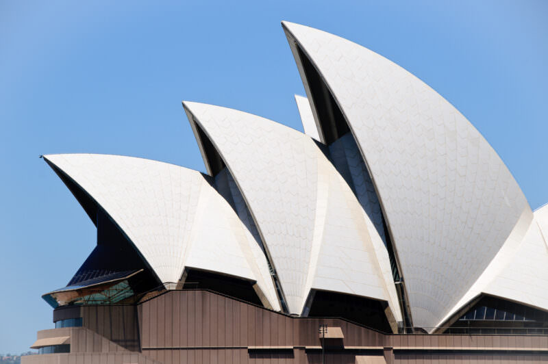 Interlocking roof shells of Sydney Opera House rising above Bennelong Point showing glossy white and matte cream tiles