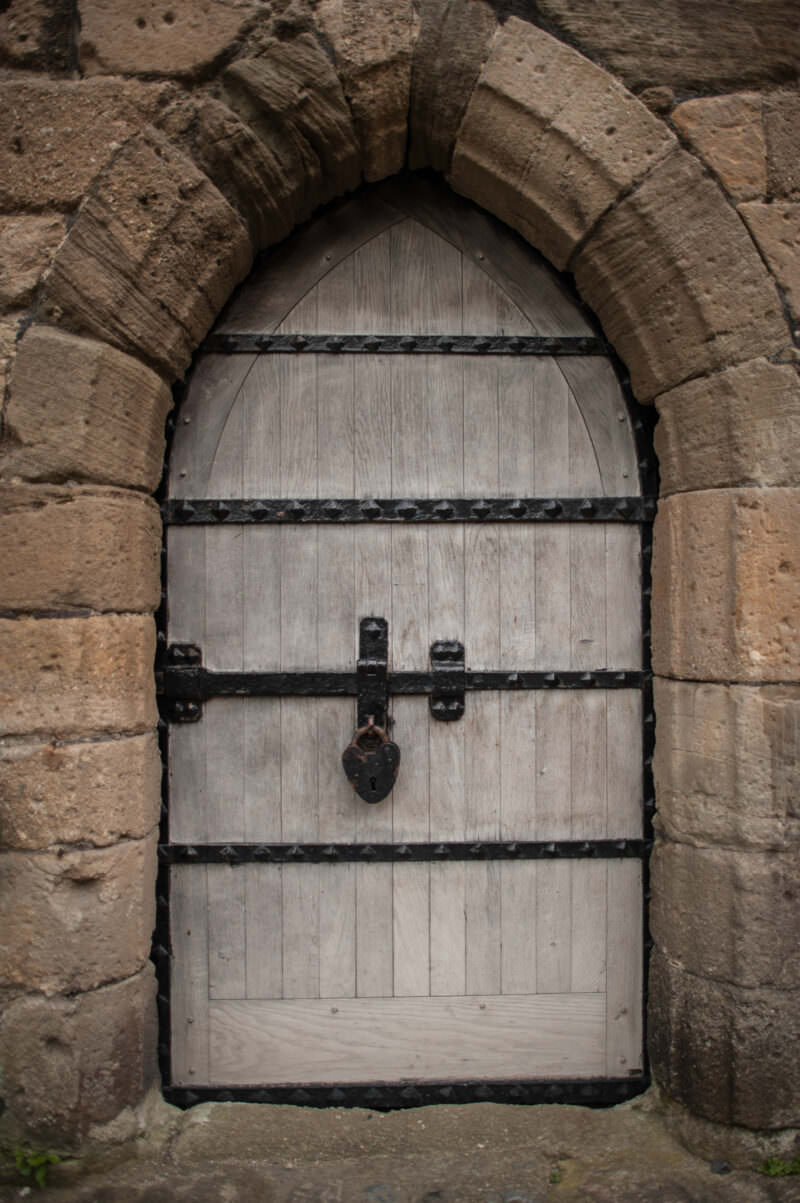 Stone arched doorway with massive masonry walls at Caernarfon Castle