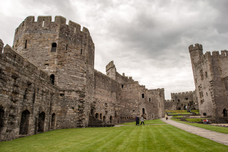 Ramparts rising above interior courtyard with polygonal towers at Caernarfon Castle