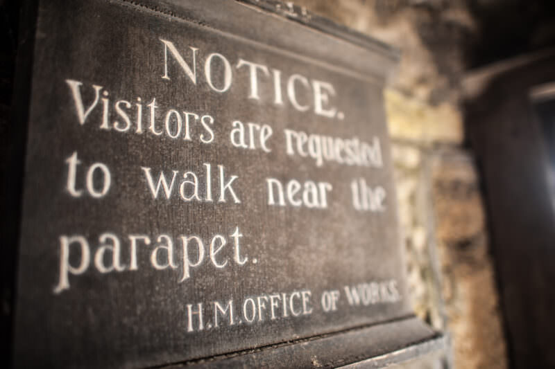 Historic H.M. Office of Works sign requesting visitors keep near parapet