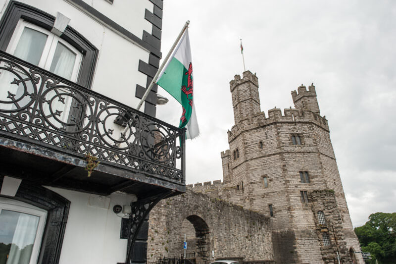 Welsh flag flying outside Anglesey Arms pub near Caernarfon Castle walls