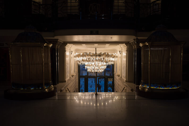 Crystal chandelier beneath vaulted marble archway at Gran Hotel Ciudad de Mexico entrance, viewed from lobby floor