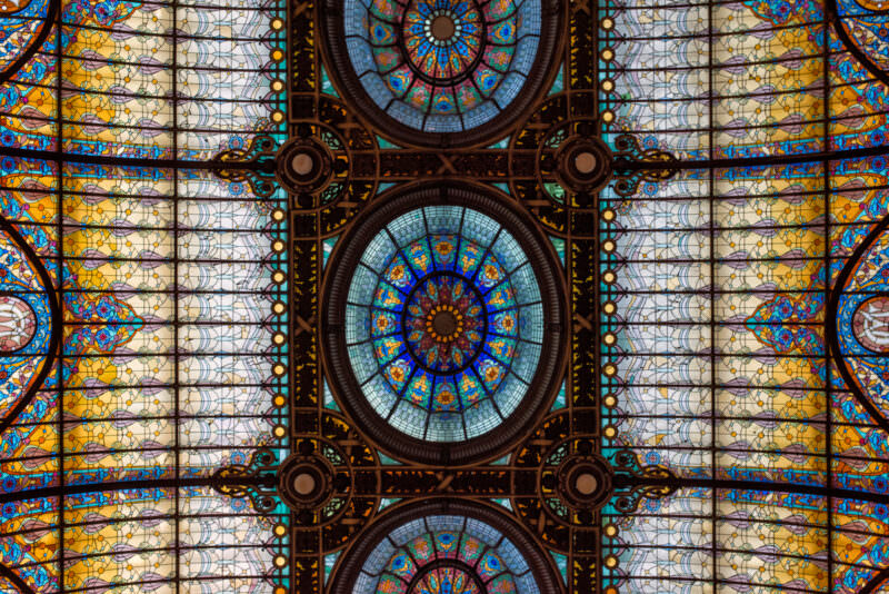 Detailed view of Gran Hotel Ciudad de Mexico ceiling showing three parallel medallions with blue and amber radial patterns
