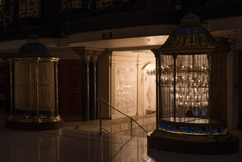 Ornate birdcage-style elevator enclosures at Gran Hotel Ciudad de Mexico with crystal drops and blue glass bases
