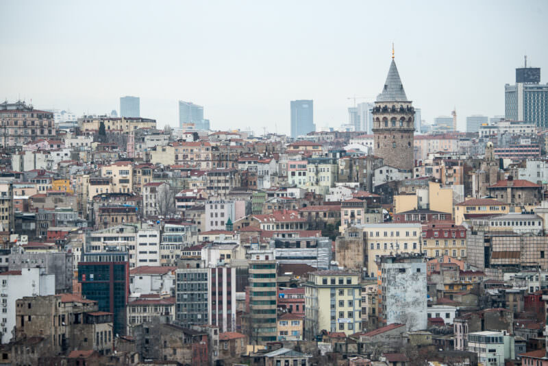 The conical-capped Galata Tower rises above the dense rooftops of Beyoğlu seen from the Karaköy waterfront