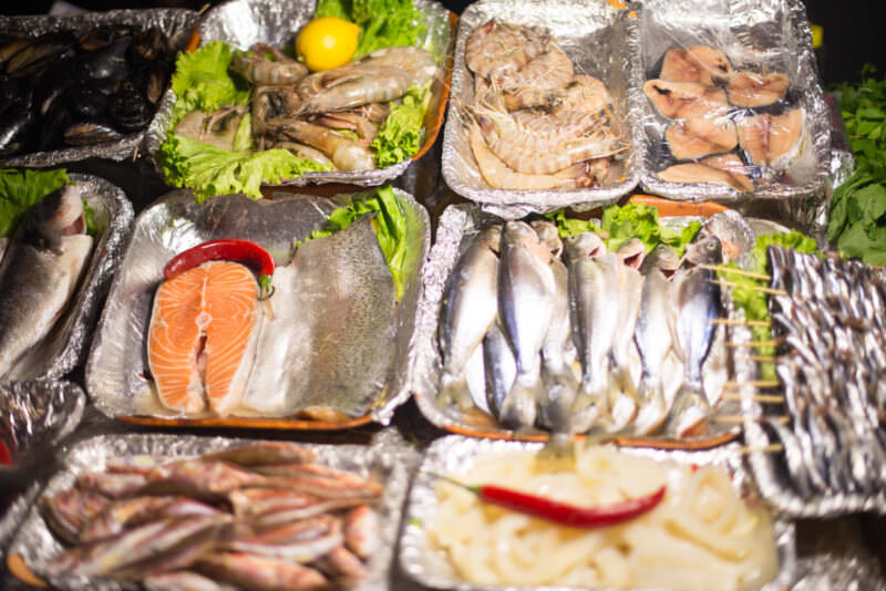 Foil trays of salmon, shrimp, mussels and fish displayed at a Karaköy waterfront seafood stall