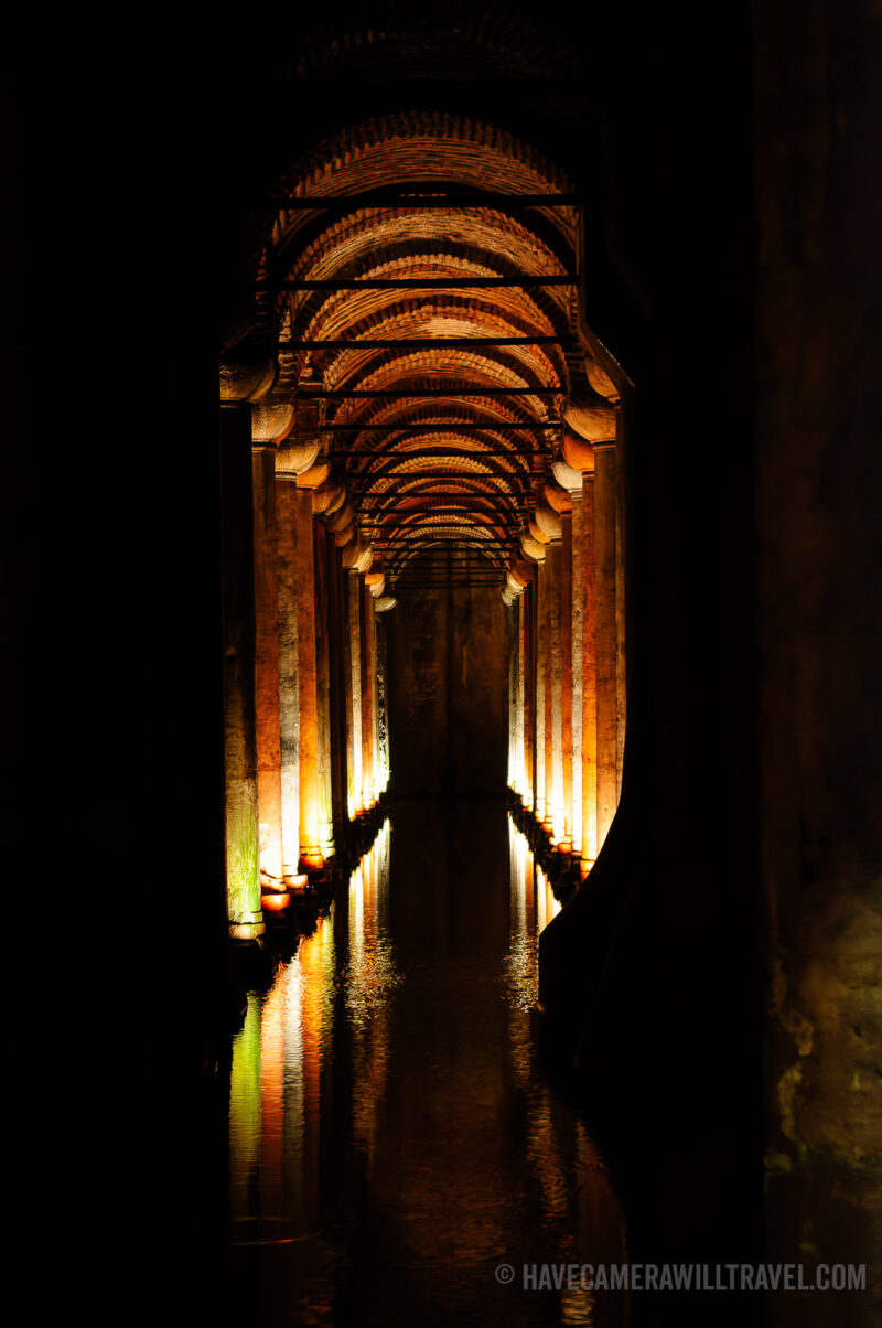 Vaulted brick ceiling and glowing column-lined passage reflected in the Basilica Cistern's water