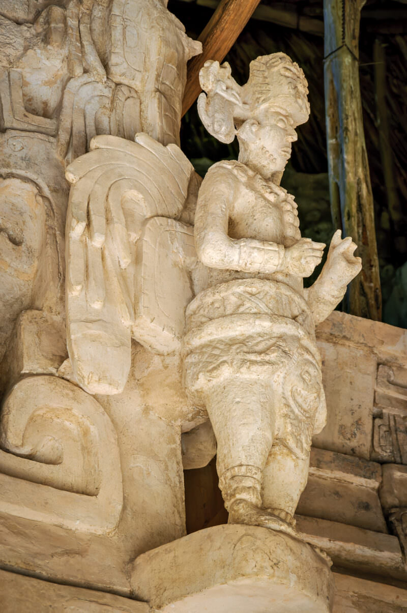 Stucco figure with zoomorphic headdress and feathered back-rack on the Sak Xok Naah façade at Ek' Balam