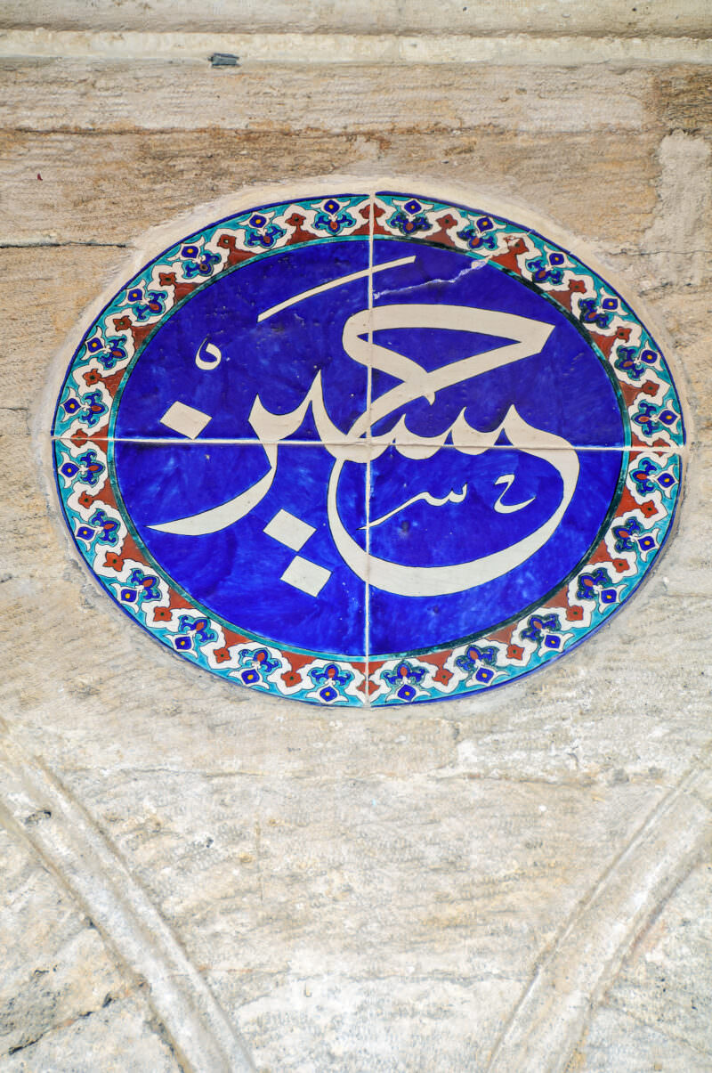 Circular Iznik tile medallion with Arabic calligraphy set into an exterior wall of Rustem Pasha Mosque