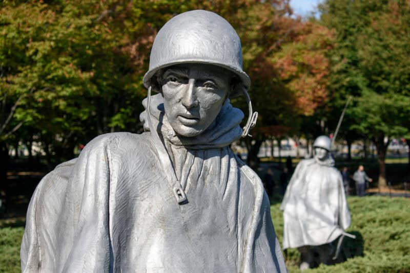 Close-up of a Korean War Veterans Memorial soldier statue in a poncho with another figure behind