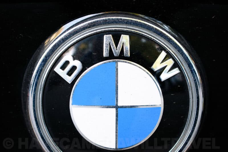 Close-up of a chrome BMW roundel badge on a black car surface