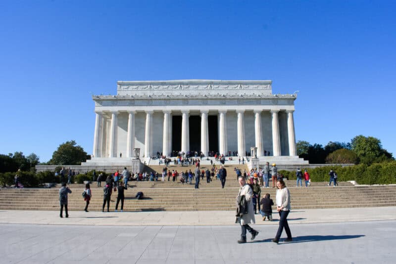 Lincoln Memorial exterior with crowds of visitors on the plaza and steps in bright sunlight