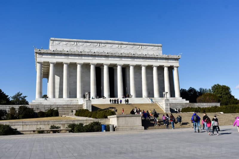 Lincoln Memorial's colonnaded facade and grand staircase with visitors walking below