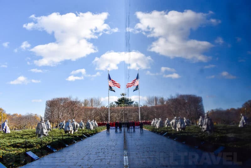 Korean War Veterans Memorial reflecting wall showing mirrored flags and soldier statues
