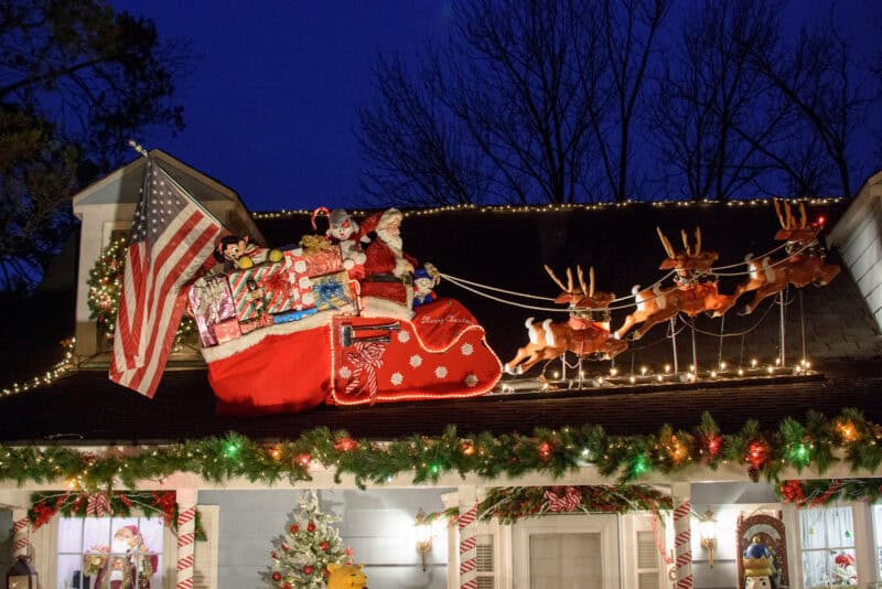 Rooftop Christmas display with a Santa sleigh and reindeer figures lit at dusk