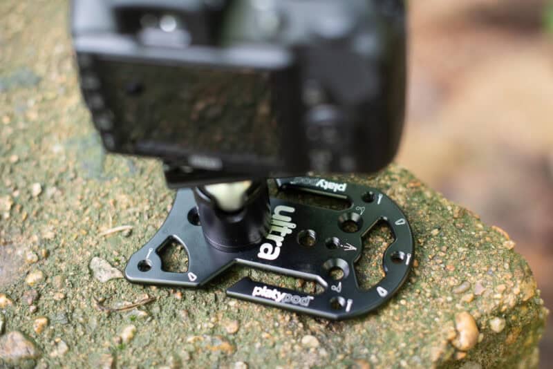 Camera mounted on a Platypod Ultra resting on a rock, using it as a compact tripod