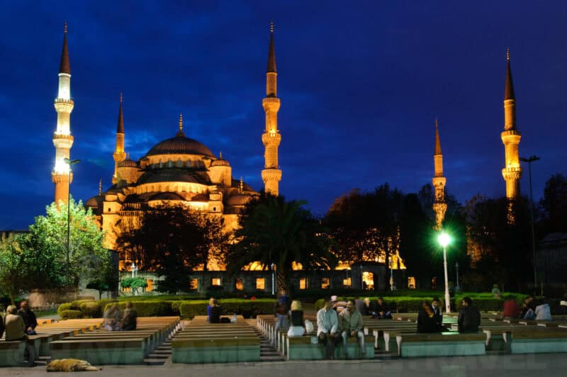 The Blue Mosque in Istanbul illuminated at night with its minarets against a dark sky