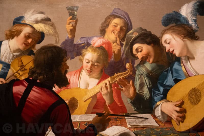 Old master painting of musicians and revelers gathered around a table with lutes and a wine glass
