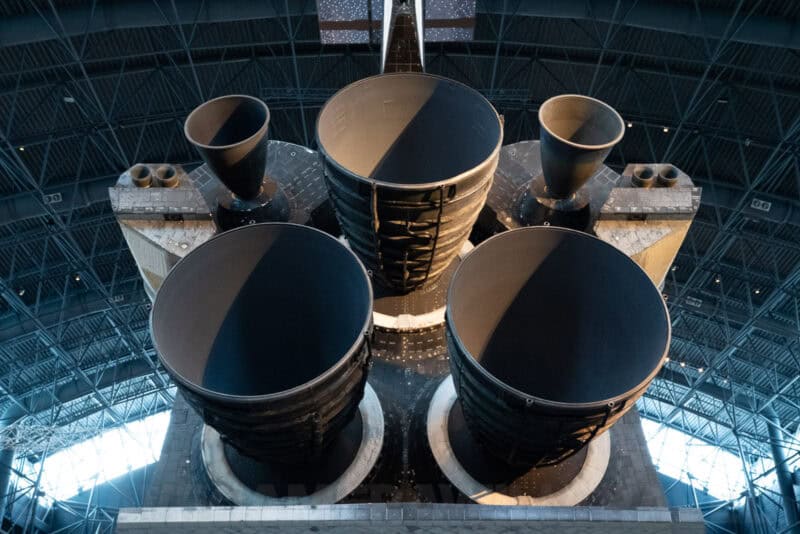 Close-up of a space shuttle's main engine nozzles and solid rocket booster exhausts inside a museum display