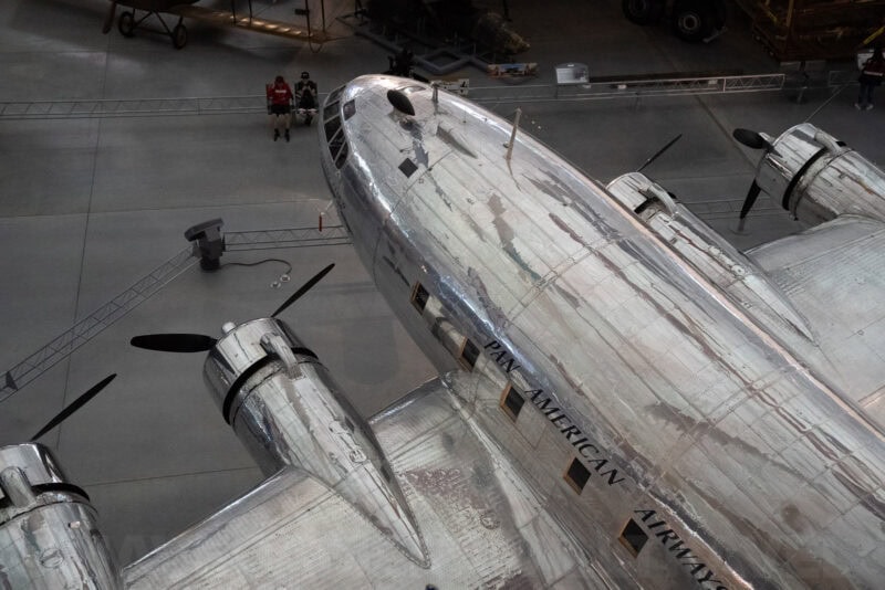 Polished silver nose of a vintage Pan American Airways propeller plane in a museum hangar
