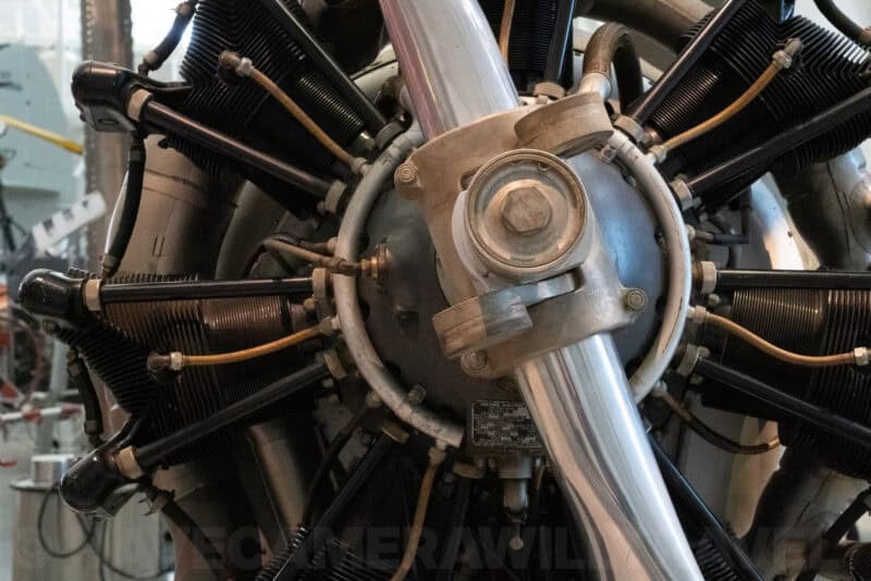 Close-up of a vintage radial aircraft engine with exposed cylinders and propeller hub