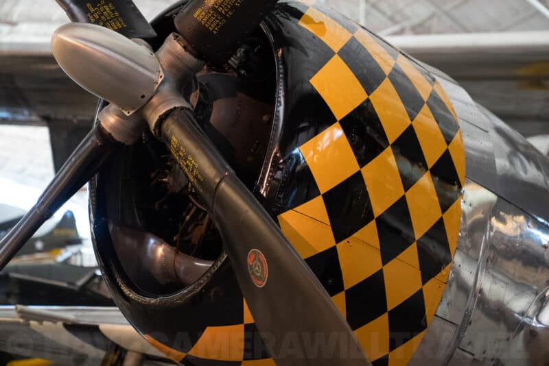 Close-up of a vintage aircraft's checkered yellow and black engine cowling with propeller