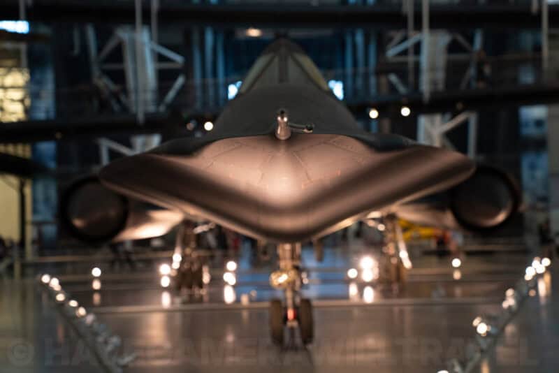 Head-on view of a Lockheed SR-71 Blackbird spy plane's nose in a dim museum hangar