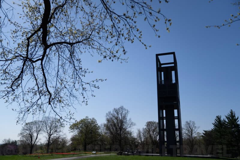 Netherlands Carillon tower silhouetted against a clear blue sky beneath bare tree branches