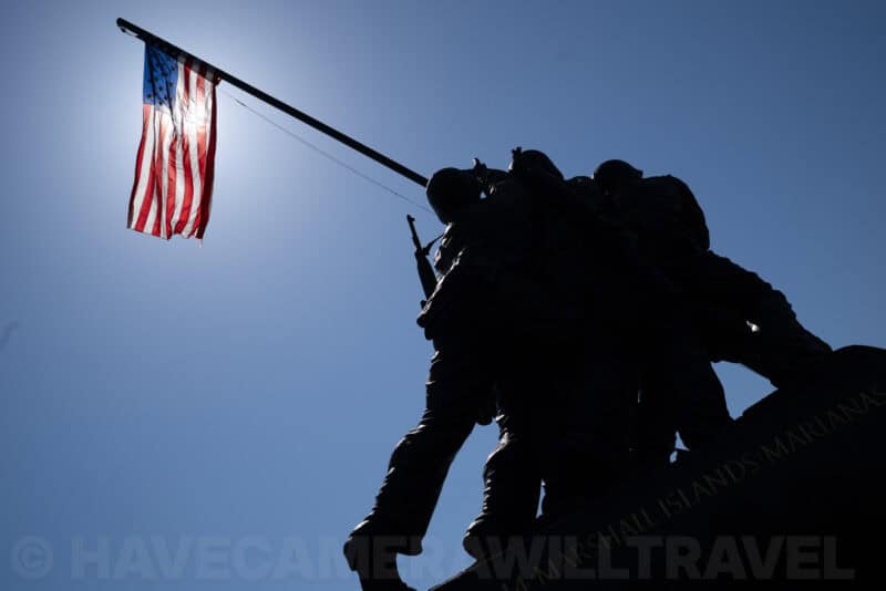 Iwo Jima Memorial statue silhouetted against the sky with an American flag flying
