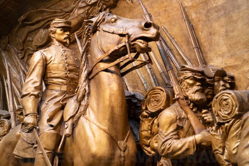Bronze relief sculpture of a mounted Civil War officer and soldiers with rifles