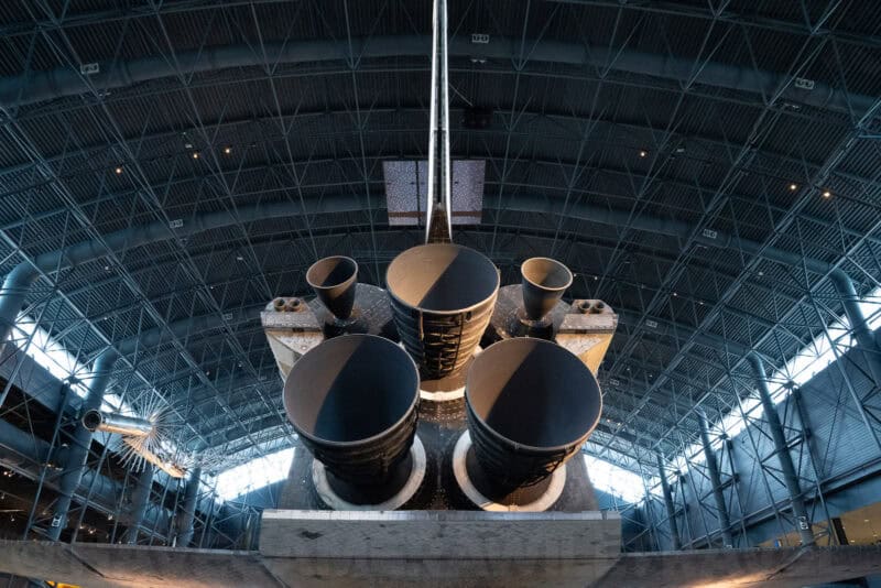Space shuttle main engine nozzles viewed from below inside a large aircraft hangar museum
