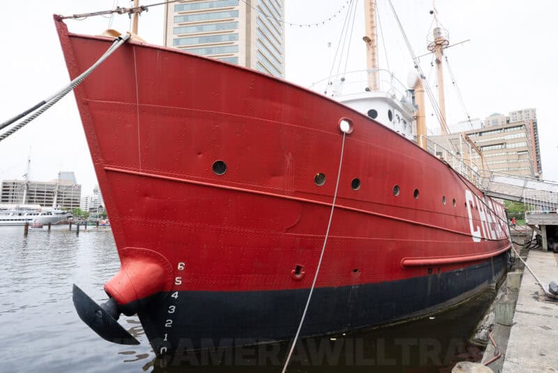 Red hull of the historic Chesapeake lightship moored at a Baltimore harbor dock