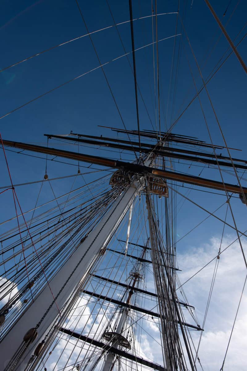 Looking up at the Cutty Sark's masts and rigging against a blue sky