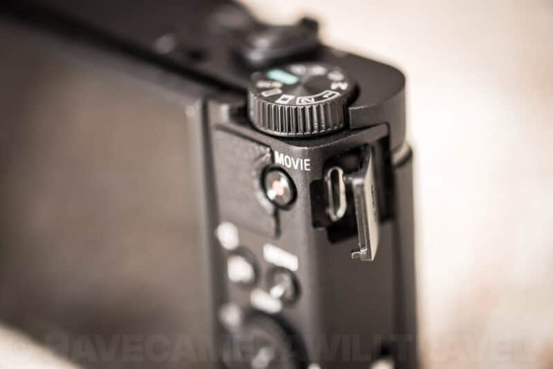Sony HX99 side view showing the open micro-USB port door next to the Movie record button