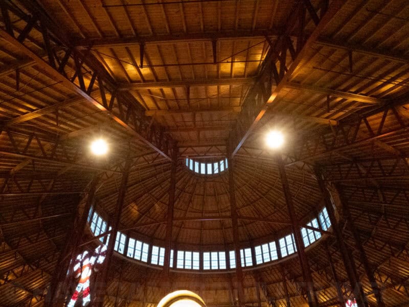 Domed wooden ceiling with exposed roof trusses and a curved band of windows lit from below