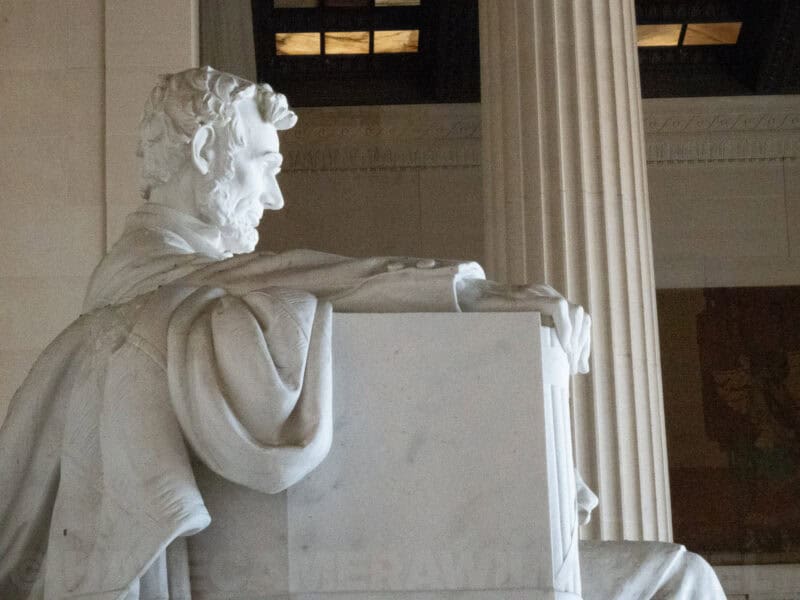 Side view of the seated Lincoln Memorial statue beside tall Ionic columns