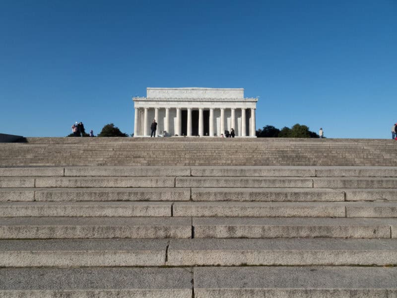 Wide stone steps leading up to the Lincoln Memorial under a clear blue sky