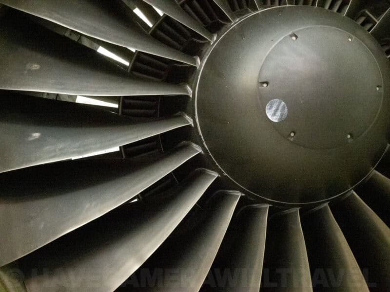 Close-up of a jet engine turbine fan blades and hub in low light