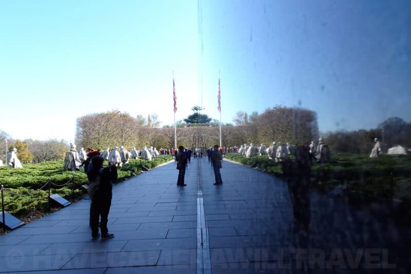 Visitors walking along the Korean War Veterans Memorial's reflective black wall