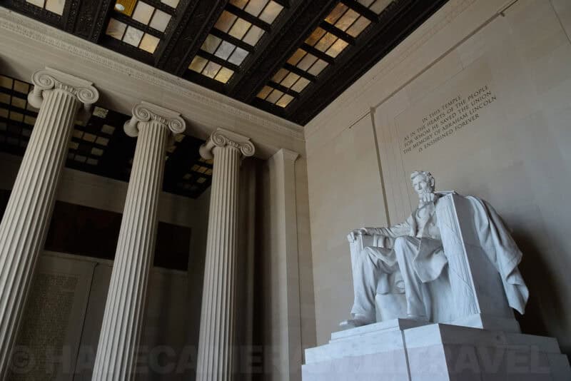 Lincoln Memorial statue and inscribed wall seen alongside its Ionic columns