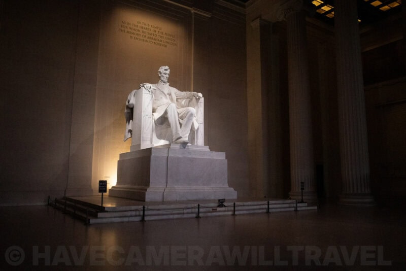 Abraham Lincoln statue glowing under interior lighting inside the Lincoln Memorial
